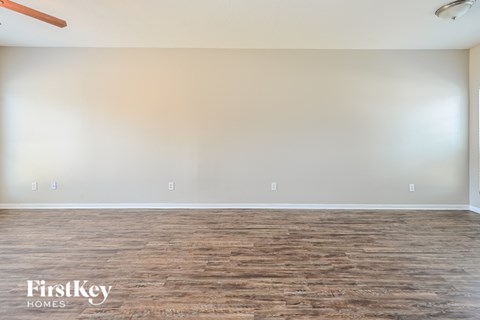 A room with wooden flooring and a ceiling fan.