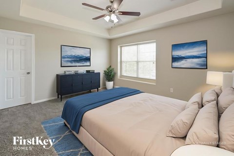A bedroom with a bed, a dresser, and two pictures on the wall.