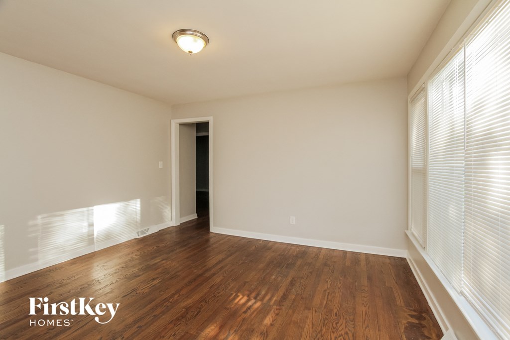 a living room with wood flooring and large windows