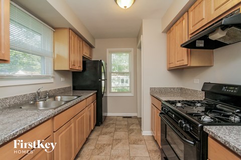 the kitchen has granite counter tops and black appliances