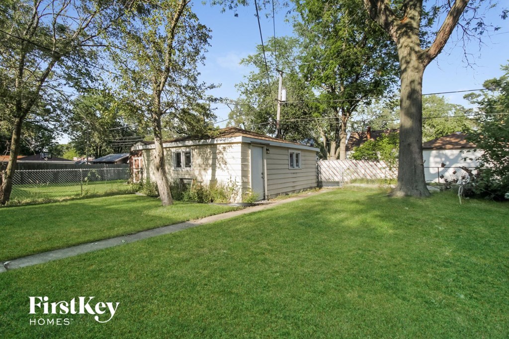 a tiny house in a backyard with a yard and a tree