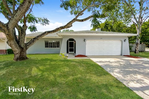 a white house with a lawn and a garage door