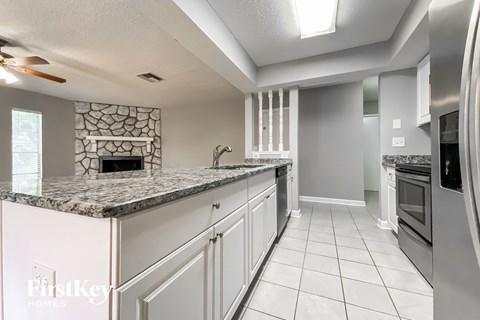 a kitchen with white cabinets and granite counter tops