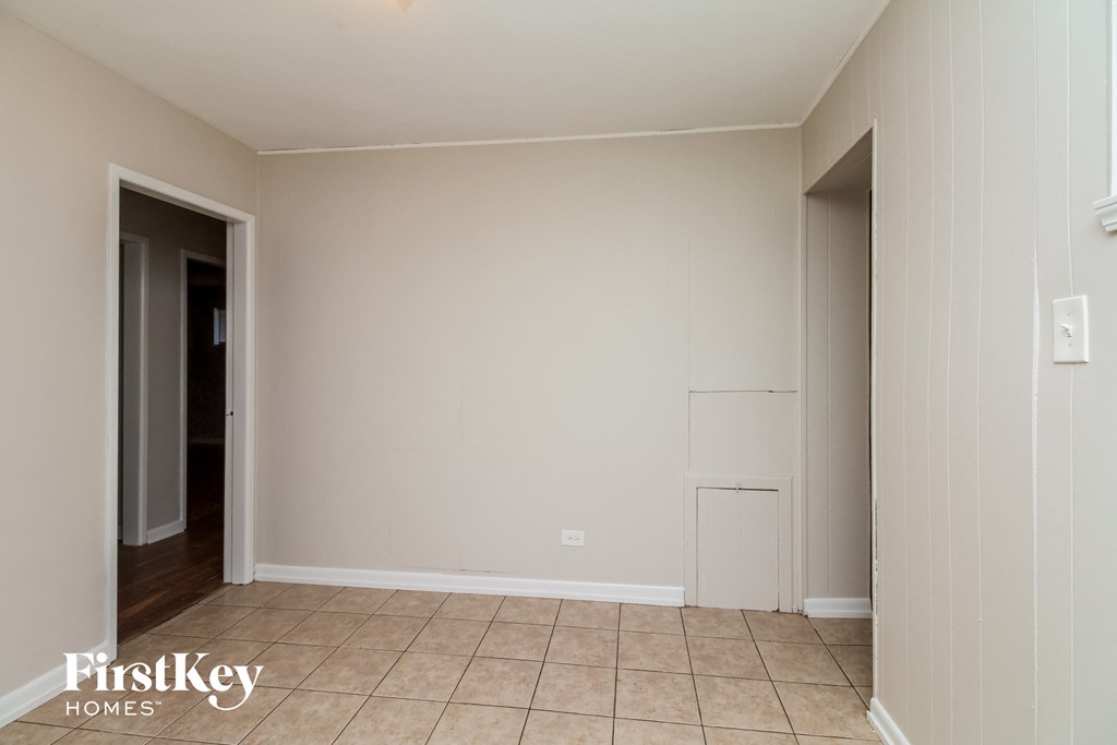 A room with a tiled floor and a doorway leading to another room.