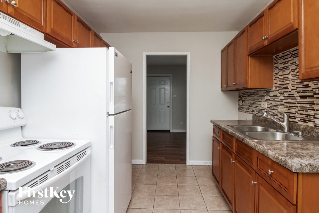 A kitchen with a white fridge and stove.