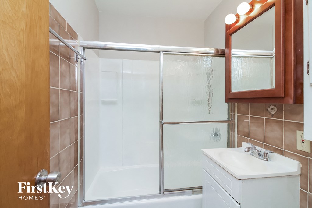 A bathroom with a white sink and a mirror.