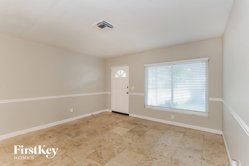 an empty room with a window and a white door