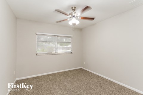a bedroom with a ceiling fan and a window