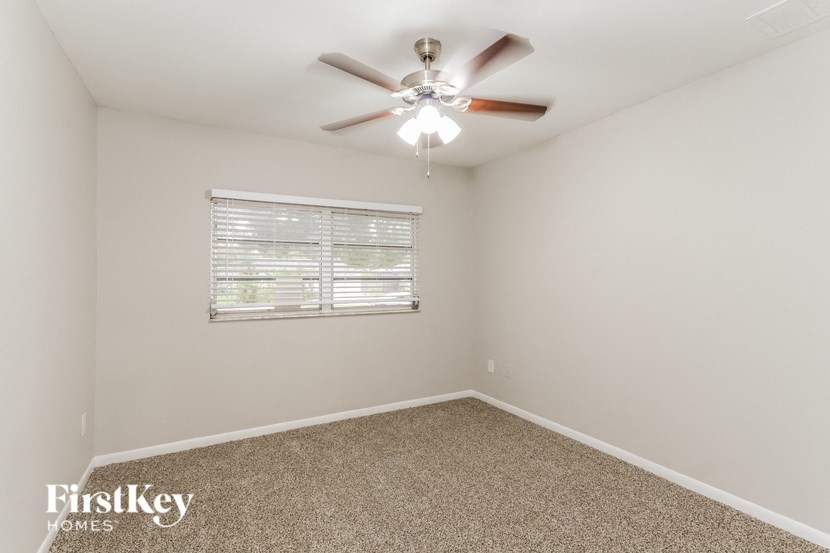 a bedroom with a ceiling fan and a window