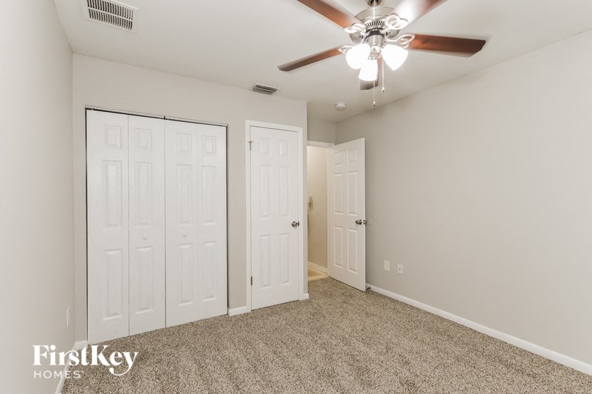 a bedroom with two closets and a ceiling fan