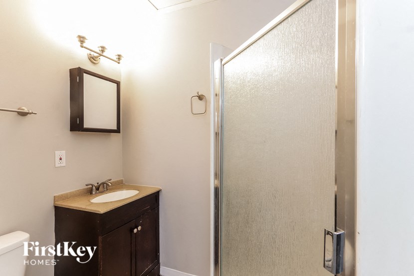 a bathroom with a shower and a sink and a mirror