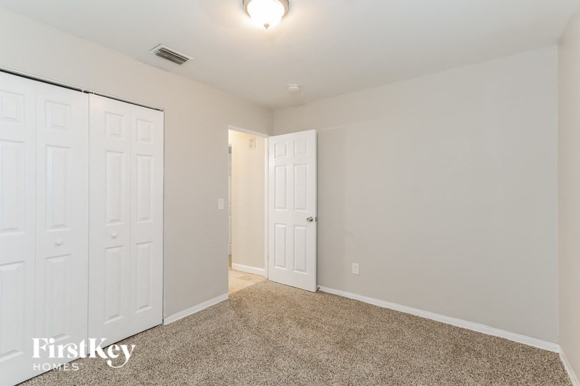 a bedroom with two white closets and a carpeted floor