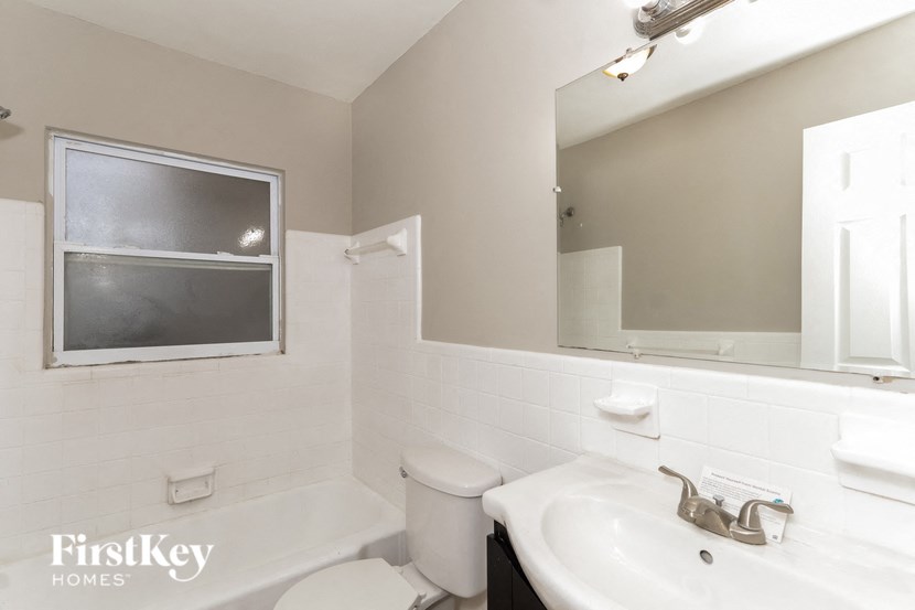 a bathroom with a sink toilet and a mirror
