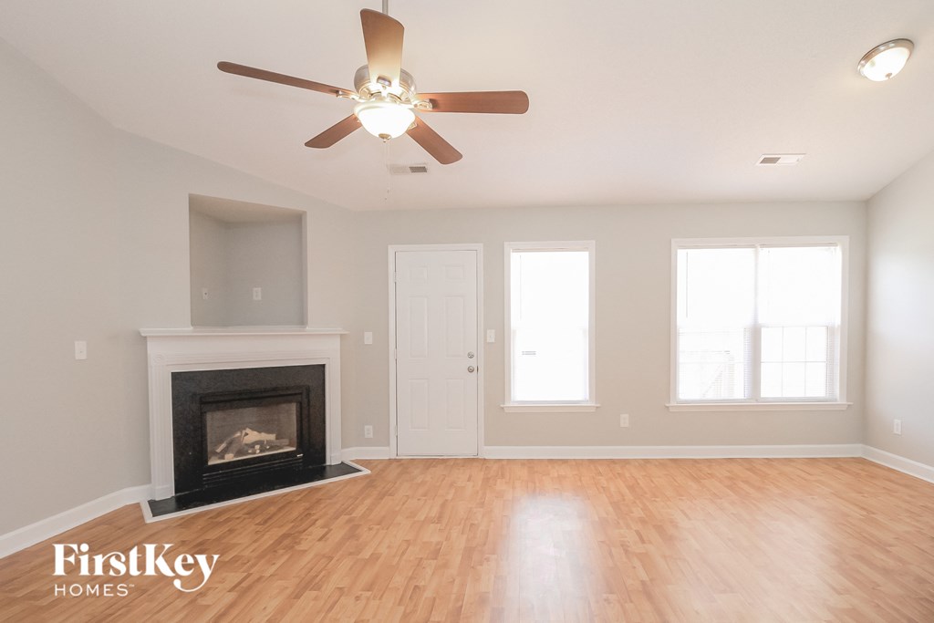 A room with a fireplace and a ceiling fan.