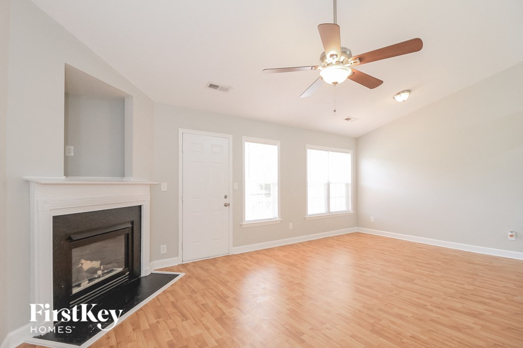 A room with a fireplace and a ceiling fan.