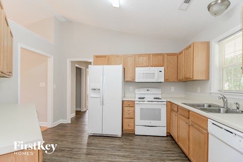 A kitchen with wooden cabinets and white appliances.