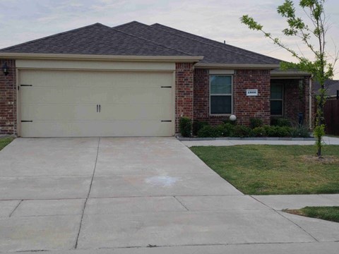 a white driveway in front of a brick house