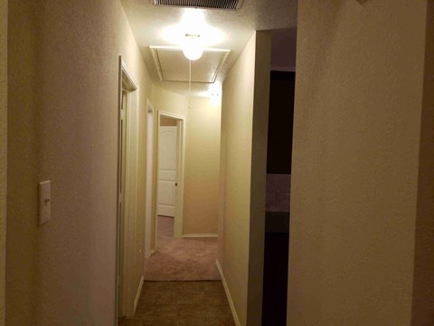 a hallway with a hallway light and a door to a bedroom
