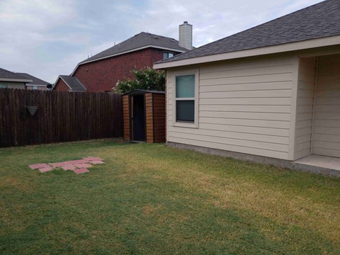 a backyard with a house and a yard with grass