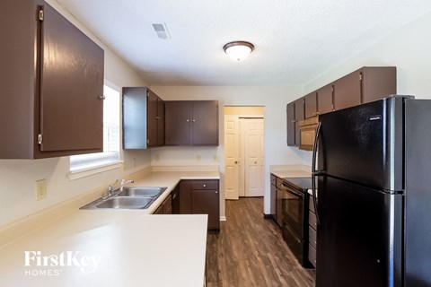 a kitchen with black appliances and white counter tops and a black refrigerator