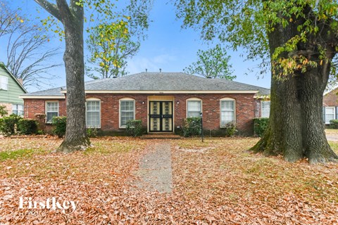 a brick house with two trees in front of it