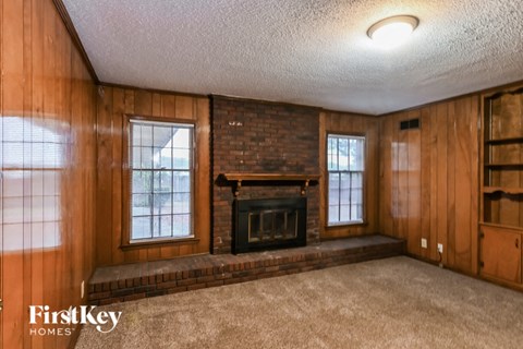 the living room of a house with a brick fireplace