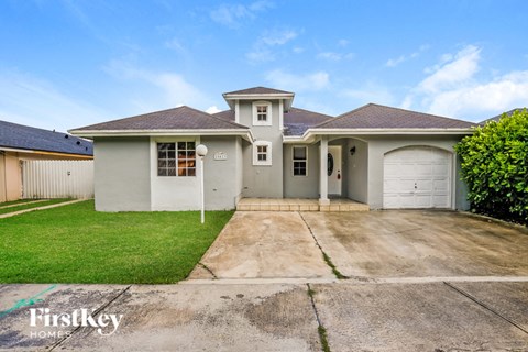 a white house with a driveway and a garage door