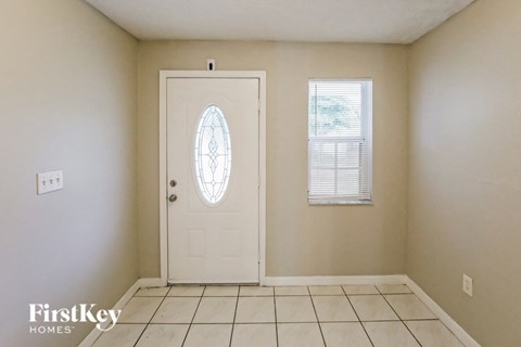 the living room has a tile floor and a white door