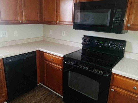 a kitchen with a black stove and a microwave