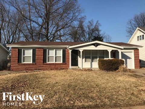 A brick house with a white door and a sign that says FirstKey Homes.