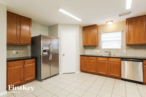 A kitchen with wooden cabinets and a stainless steel refrigerator.