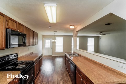 A kitchen with wooden cabinets and a black stove top oven.