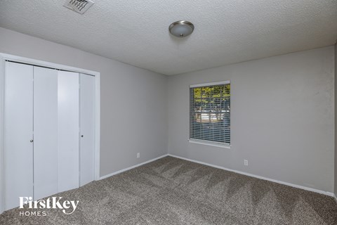 a bedroom with carpet and a door to a closet