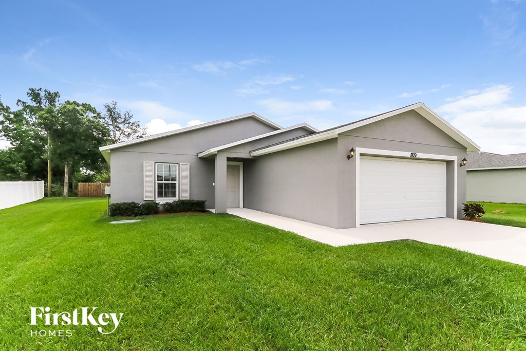 a gray house with a lawn and a garage