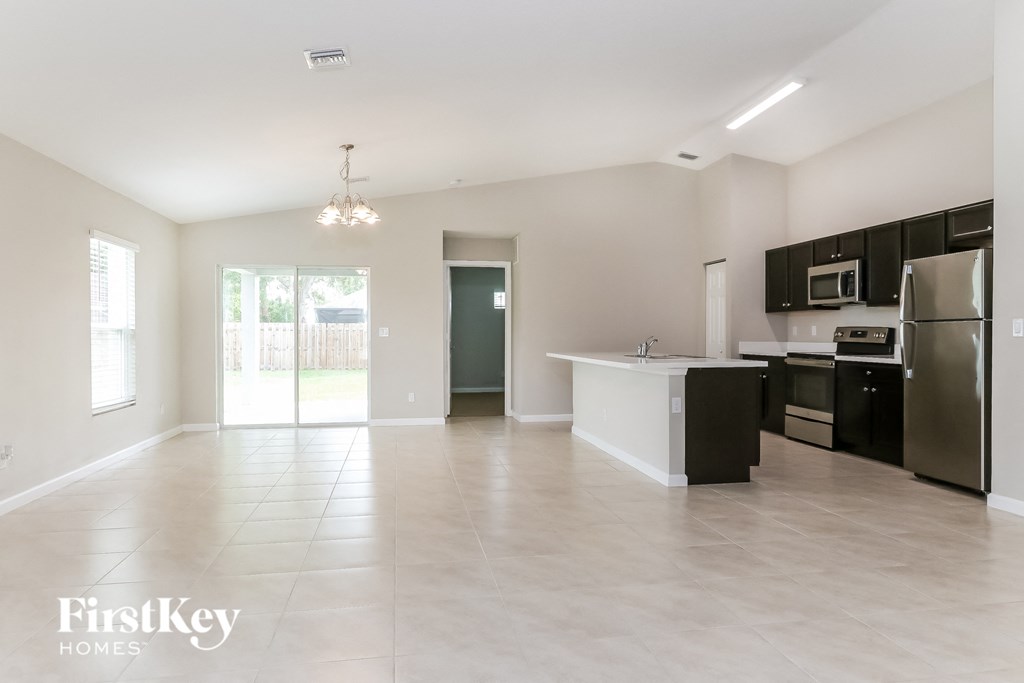 an empty kitchen with stainless steel appliances and tile flooring