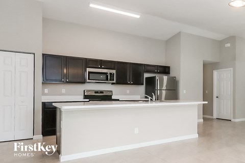 a kitchen with black cabinets and a white counter top