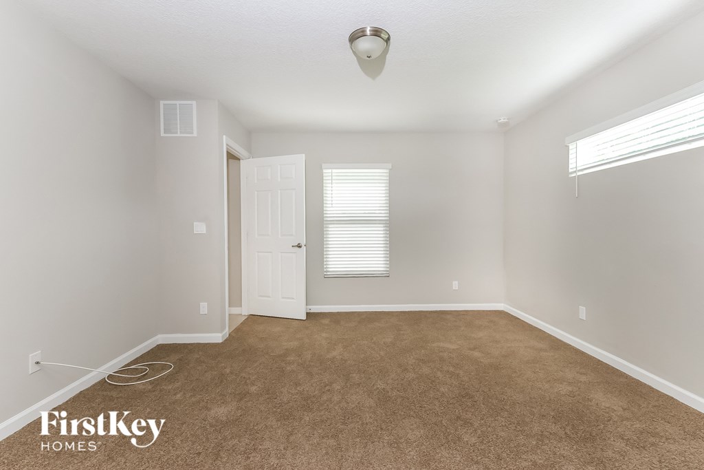 an empty room with a carpeted floor and a white door