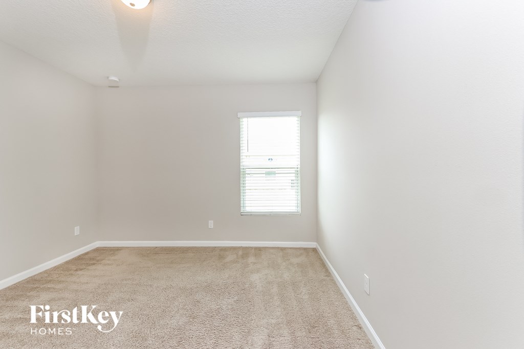 a bedroom with a carpeted floor and a window