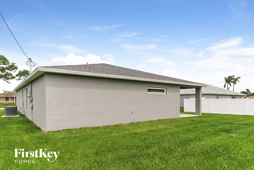 a small white house with a grass yard and a white fence