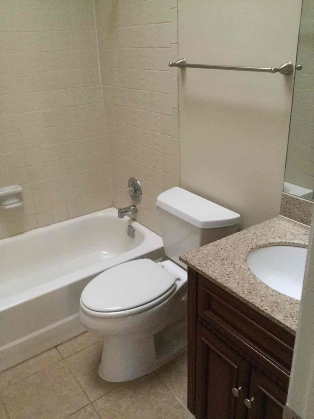 A white toilet sits next to a bathtub in a bathroom.