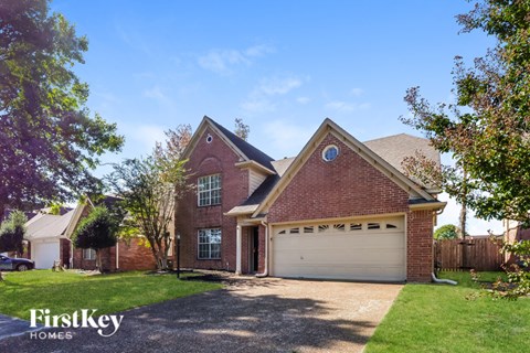 A brick house with a garage is for sale.