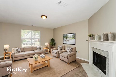 A living room with a fireplace and a painting on the wall.