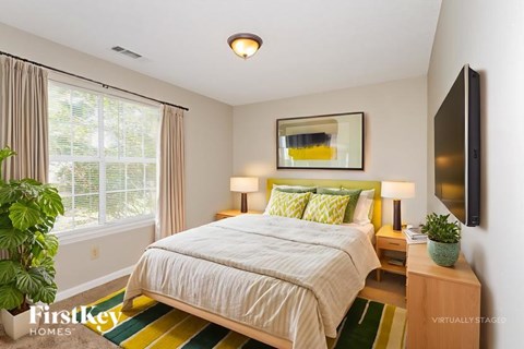 A bedroom with a large bed and a flat screen TV mounted on the wall.