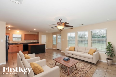 A living room with a white couch and a ceiling fan.