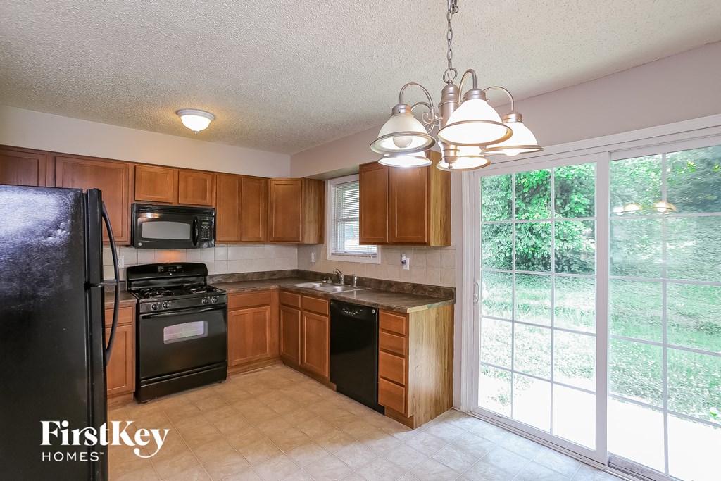 A kitchen with wooden cabinets and black appliances.