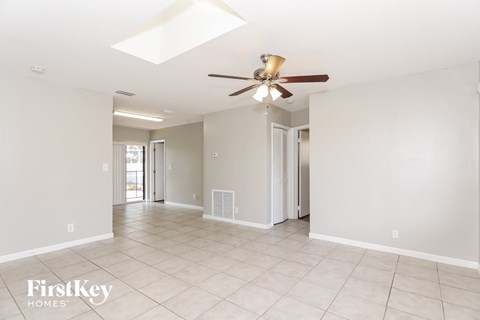 A spacious room with a ceiling fan and tiled flooring.
