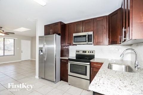 A kitchen with a stainless steel refrigerator, oven, and microwave.