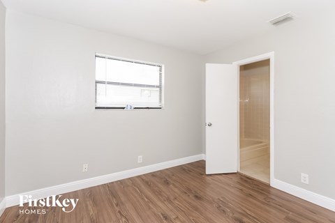 A room with a wooden floor and a white door.