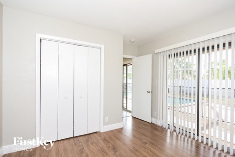 A white closet with a sliding door is in the room.