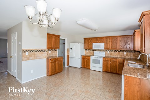A kitchen with wooden cabinets and a white fridge.